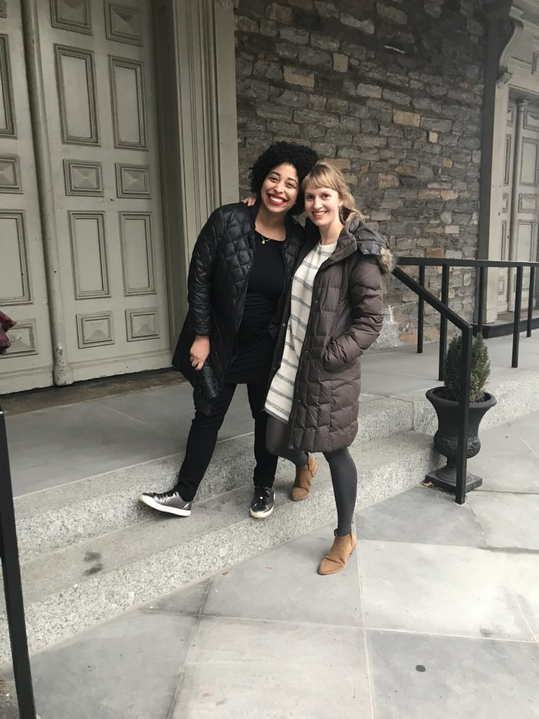Kristin Juarez (left) and Lydia Bell (right) smile and lean against each other on the front steps of St. Mark’s Church.