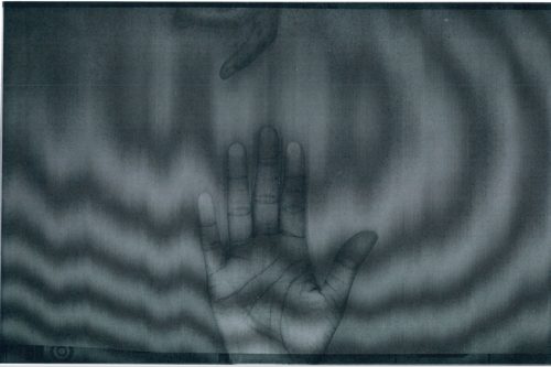 Hands. Two hands appear on the page; one hand has a palm spread wide and in the other, the curled fingers are barely visible. Waves radiate across the page.